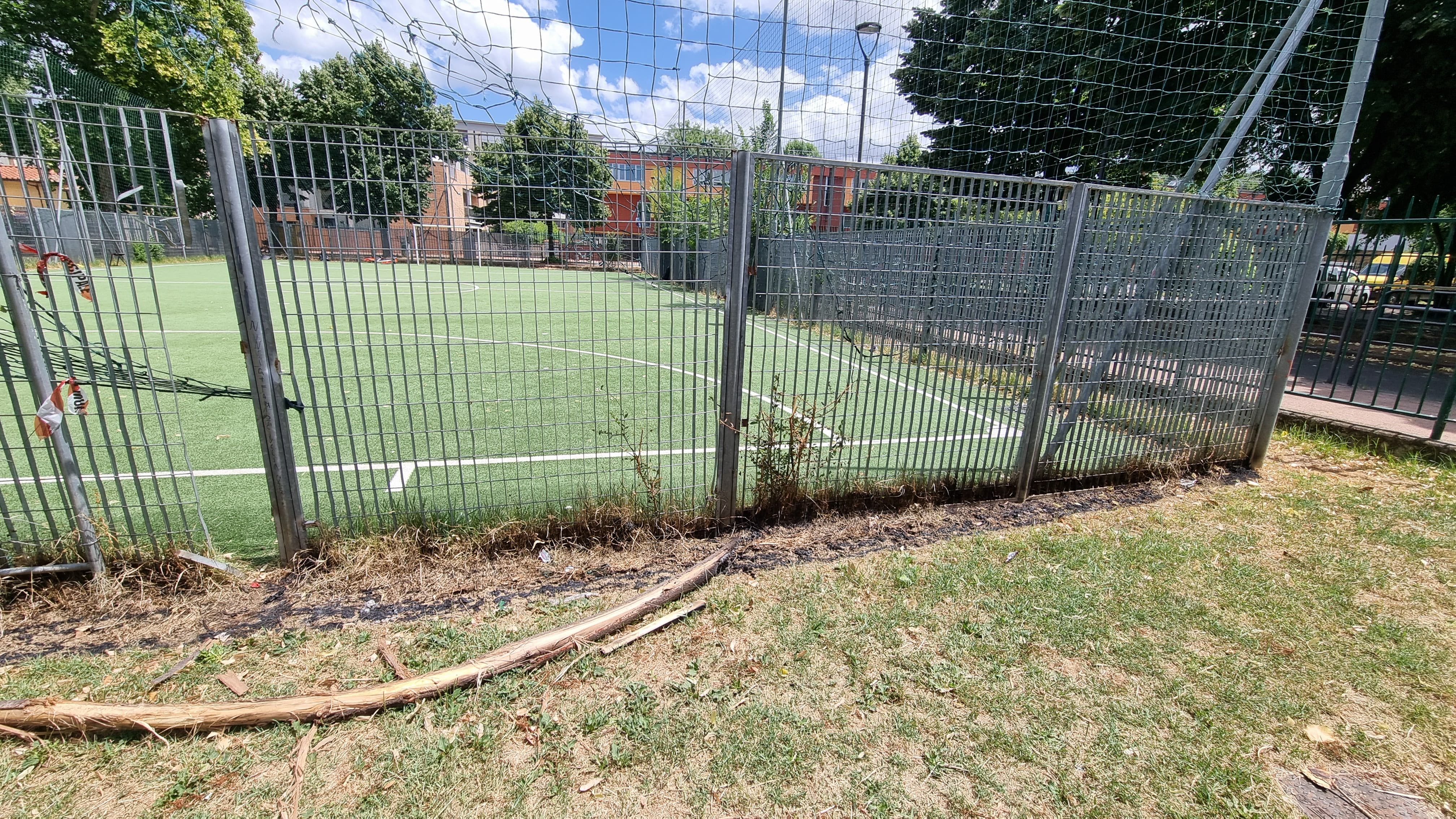 La cenere e i detriti dell'incendio a margine del campetto da calcio solitamente affollato dai più piccoli